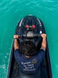 Reason to Stay Alive? navy T-shirt worn on a jet ski